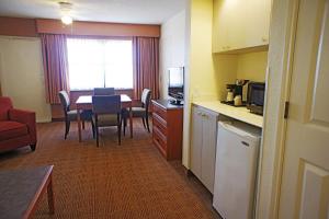 a room with a kitchen and a table with chairs at La Quinta by Wyndham Coral Springs University Dr in Coral Springs