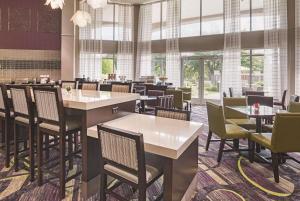 uma sala de jantar com mesas, cadeiras e janelas em La Quinta by Wyndham Fort Worth North em Fort Worth