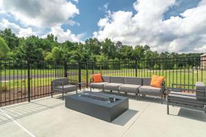 a patio with a couch and chairs and a fence at La Quinta by Wyndham Opelika Auburn in Opelika