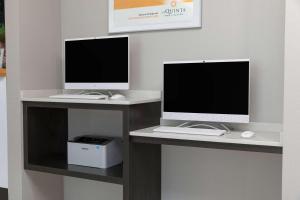 a desk with two computer monitors and a keyboard and mouse at La Quinta by Wyndham Atlanta Douglasville in Douglasville
