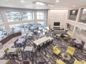 une cafétéria avec des tables et des chaises et une télévision dans l'établissement La Quinta by Wyndham Denver Tech Center, à Greenwood Village