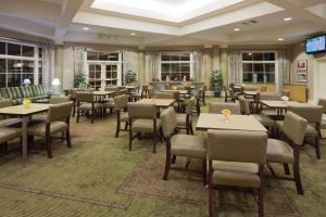 a restaurant with tables and chairs in a room at La Quinta by Wyndham Salt Lake City Airport in Salt Lake City