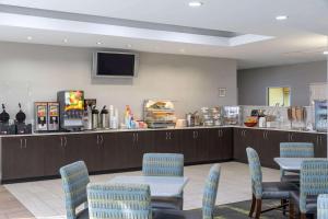 a waiting room with tables and chairs and a counter at La Quinta by Wyndham Atlanta Douglasville in Douglasville