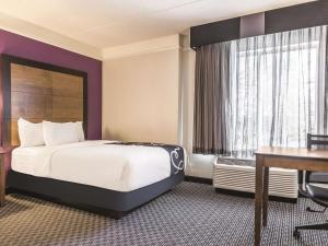 a hotel room with a bed and a desk at La Quinta by Wyndham Alexandria Airport in Alexandria +32 photos