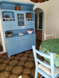 um armário azul num quarto com uma mesa e cadeiras em casa fiorella em San Bernardino