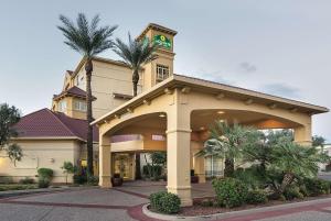 a hotel with palm trees in front of a building at La Quinta by Wyndham Phoenix Mesa West in Mesa