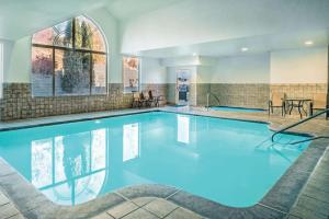 a large pool with blue water in a building at La Quinta by Wyndham Moscow Pullman in Moscow