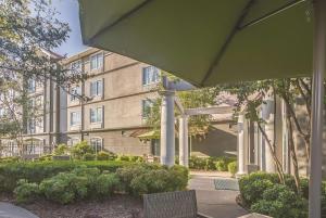 a apartment building with a patio and bushes in front of it at La Quinta by Wyndham Oklahoma City Norman in Norman