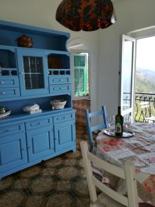 uma sala de jantar com armários azuis e uma mesa em casa fiorella em San Bernardino