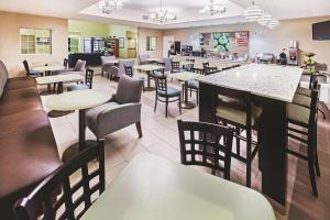 a restaurant with tables and chairs and a bar at La Quinta by Wyndham Corpus Christi Northwest in Corpus Christi