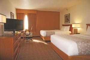 a hotel room with two beds and a flat screen tv at La Quinta Inn by Wyndham Kansas City North in Kansas City