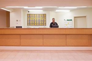 a man standing at a counter in a room at La Quinta by Wyndham Nashville Airport/Opryland in Nashville