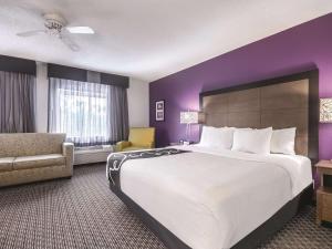 a hotel room with a large bed and a couch at La Quinta by Wyndham Hartford Bradley Airport in Windsor Locks