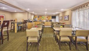 ein Restaurant mit Tischen und Stühlen und eine Bar in der Unterkunft La Quinta Inn by Wyndham Toledo Perrysburg in Perrysburg