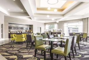 a restaurant with tables and chairs and a bar at La Quinta by Wyndham Alexandria Airport in Alexandria