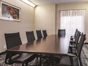 une salle de conférence avec une grande table et des chaises en bois dans l'établissement La Quinta by Wyndham Alexandria Airport, à Alexandria