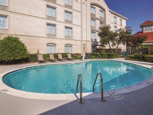 a large swimming pool in front of a building at La Quinta by Wyndham Dallas Plano West in Plano