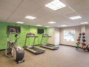 a gym with tread machines and a green wall at La Quinta by Wyndham Denver Airport DIA in Denver