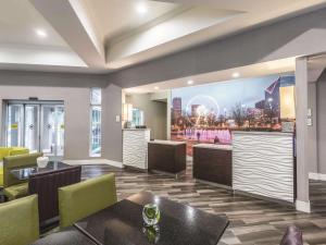 a restaurant with tables and chairs and a painting on the wall at La Quinta by Wyndham Atlanta Alpharetta in Alpharetta