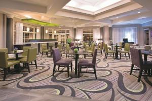 a restaurant with tables and chairs and a piano at La Quinta by Wyndham Mesa Superstition Springs in Mesa