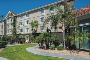 a building with palm trees in front of it at La Quinta by Wyndham Phoenix Chandler in Phoenix