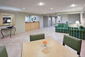 a waiting room with a table and green chairs at La Quinta by Wyndham Mansfield OH in Mansfield