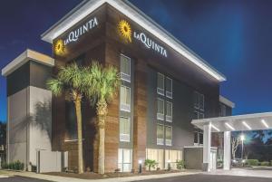 a building with palm trees in front of it at La Quinta by Wyndham Myrtle Beach - N. Kings Hwy in Myrtle Beach