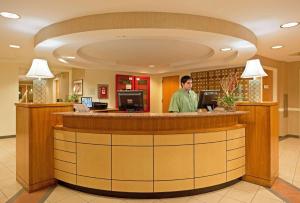 a man standing at a counter in a lobby at La Quinta by Wyndham Boston Somerville in Somerville