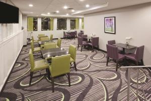 a waiting room with tables and chairs on a carpet at La Quinta by Wyndham Minneapolis Bloomington W in Bloomington