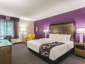 a hotel room with a bed and a purple wall at La Quinta by Wyndham Columbia / Fort Meade in Jessup