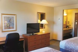 a hotel room with a bed and a television on a dresser at La Quinta by Wyndham El Paso West Bartlett in El Paso
