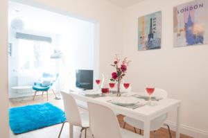 a white dining room with a white table and chairs at The Wellington - Ideal for Professionals in Burton upon Trent