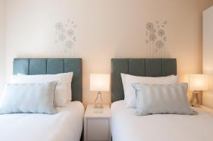 two beds in a room with two lamps at The Wellington - Ideal for Professionals in Burton upon Trent