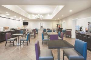 a restaurant with tables and chairs and a kitchen at La Quinta by Wyndham Fort Walton Beach in Fort Walton Beach +27 photos