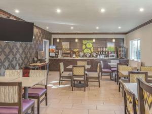 ein Restaurant mit Tischen und Stühlen und eine Bar in der Unterkunft La Quinta Inn by Wyndham Olympia - Lacey in Lacey