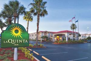 
a large palm tree in front of a hotel at La Quinta Inn by Wyndham Orlando International Drive North in Orlando
