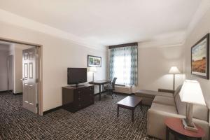 a hotel room with a couch and a television at La Quinta by Wyndham Mansfield TX in Mansfield