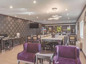 a restaurant with purple chairs and tables and a bar at La Quinta Inn by Wyndham Olympia - Lacey in Lacey