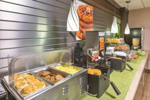 a buffet line with various pastries and other food at La Quinta Inn by Wyndham Austin North in Austin