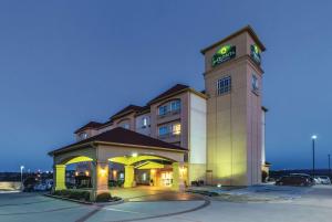 a hotel with a clock tower in a parking lot at La Quinta by Wyndham Fort Worth - Lake Worth in Fort Worth