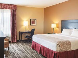 a hotel room with a bed and a desk at La Quinta by Wyndham Slidell - North Shore Area in Slidell