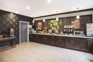a large kitchen with wooden cabinets and a counter at La Quinta Inn by Wyndham Olympia - Lacey in Lacey