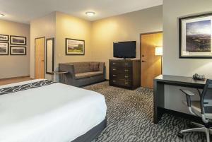 a hotel room with a bed and a desk and a television at La Quinta Inn by Wyndham Livermore in Livermore