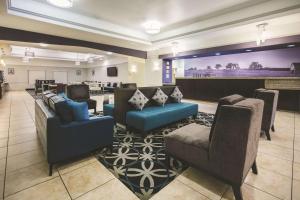 a lobby with couches and chairs and a bar at La Quinta by Wyndham Brownwood in Brownwood