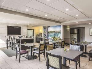 a dining room with tables and chairs and a television at La Quinta Inn by Wyndham Jupiter in Jupiter