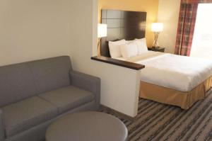 a hotel room with a bed and a couch at La Quinta Inn by Wyndham Lincoln in Lincoln