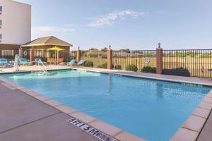 een zwembad met blauw water in een gebouw bij La Quinta by Wyndham Abilene Mall in Abilene