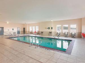 ein Pool in einem großen Raum mit Stühlen um ihn herum in der Unterkunft La Quinta by Wyndham Glen Rose in Glen Rose