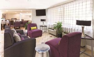 een woonkamer met paarse stoelen en een eetkamer bij La Quinta by Wyndham Miami Airport East in Miami