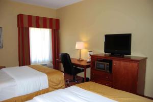 a hotel room with two beds and a desk with a television at La Quinta by Wyndham Fairfield TX in Fairfield
